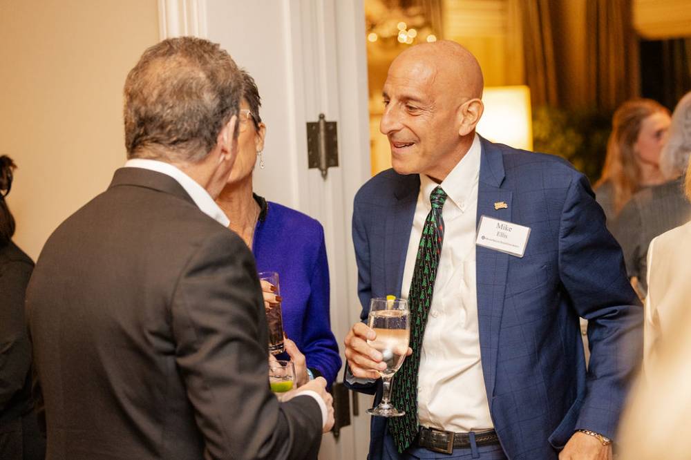 Mike Ellis speaking with another two guests at the party